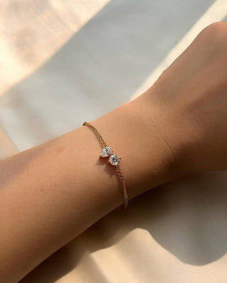 Pulsera de dos piedras con diamantes de moissanita de talla redonda y pera en oro macizo